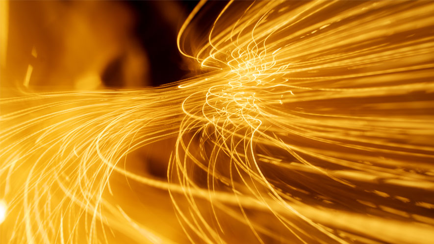 The image displays dynamic, curved light lines in an intense golden color. The lines flow in various curves, creating a sense of movement and energy. The dark background highlights the glowing lines prominently.