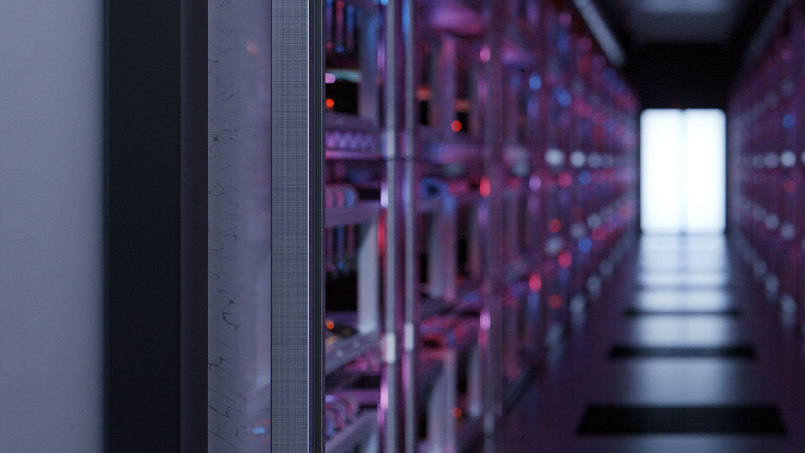 Close-up perspective of a narrow aisle in a technical facility: metal racks on both sides hold tightly arranged electronic equipment, cables and LED status lights glowing in blue and pink. 